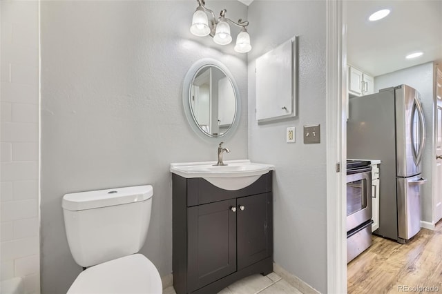 bathroom with hardwood / wood-style flooring, vanity, and toilet