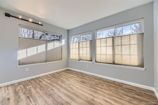 unfurnished room with hardwood / wood-style flooring