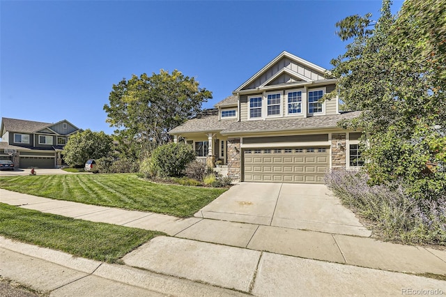 craftsman house featuring concrete driveway, an attached garage, board and batten siding, a front yard, and stone siding