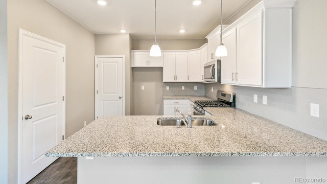 kitchen with backsplash, sink, white cabinetry, stainless steel appliances, and light stone counters