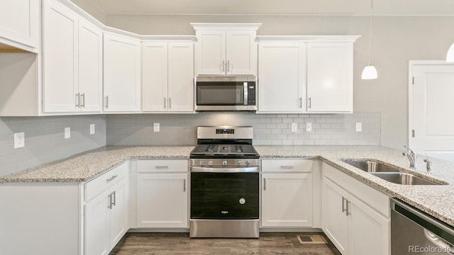 kitchen with backsplash, sink, white cabinets, and appliances with stainless steel finishes