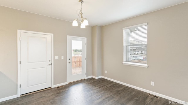 interior space featuring plenty of natural light, dark hardwood / wood-style flooring, and a chandelier