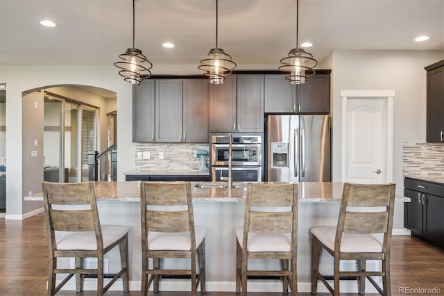 2234 S Nile St, Denver, CO 80228 - kitchen featuring stainless steel appliances, arched walkways, tasteful backsplash, recessed lighting, and dark wood finished floors