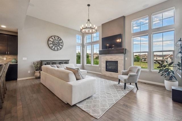 2234 S Nile St, Denver, CO 80228 - living room featuring a glass covered fireplace, a chandelier, hardwood / wood-style floors, a high ceiling, and recessed lighting