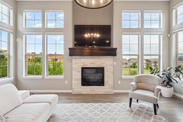 2234 S Nile St, Denver, CO 80228 - living area featuring plenty of natural light, wood finished floors, a high ceiling, and a tiled fireplace