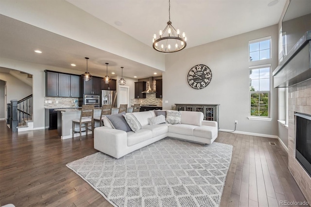 2234 S Nile St, Denver, CO 80228 - living room with a fireplace, dark wood-type flooring, a chandelier, stairs, and recessed lighting