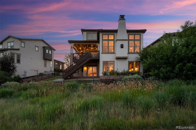 2234 S Nile St, Denver, CO 80228 - rear view of house with a chimney, stairway, stucco siding, and a tile roof