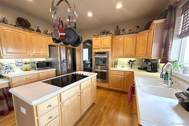 10520 W Vassar Dr, Lakewood, CO 80227 - kitchen featuring stainless steel appliances, light wood-type flooring, light countertops, a center island, and recessed lighting
