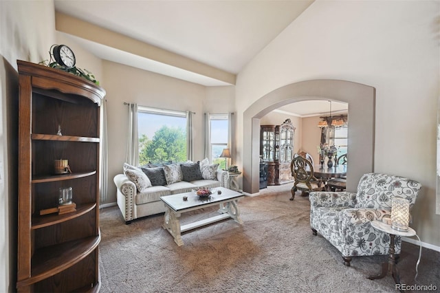 10520 W Vassar Dr, Lakewood, CO 80227 - living room featuring carpet floors, arched walkways, high vaulted ceiling, and baseboards