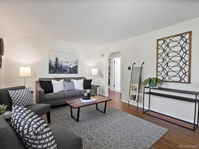4740 W Wyoming Pl, Denver, CO 80219 - living room with arched walkways, wood finished floors, and baseboards