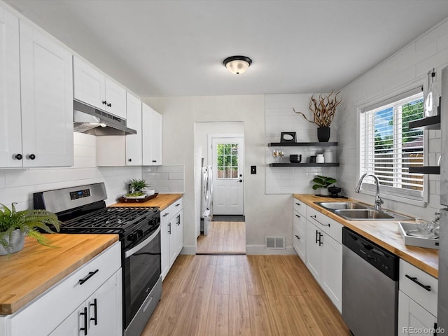 4740 W Wyoming Pl, Denver, CO 80219 - kitchen with appliances with stainless steel finishes, wood counters, under cabinet range hood, and open shelves