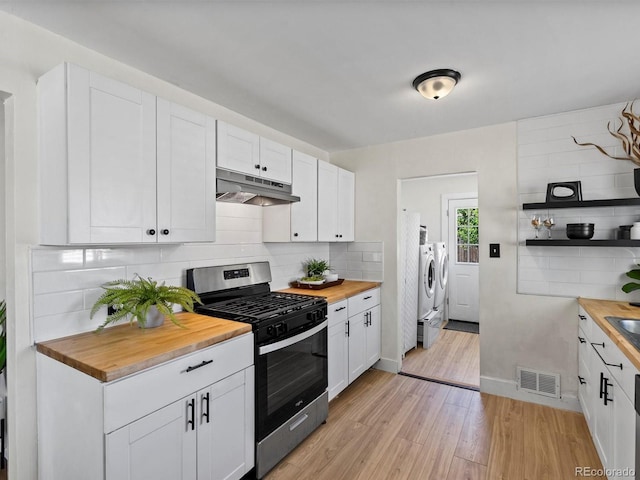 4740 W Wyoming Pl, Denver, CO 80219 - kitchen with wooden counters, stainless steel gas stove, under cabinet range hood, washing machine and dryer, and light wood-type flooring