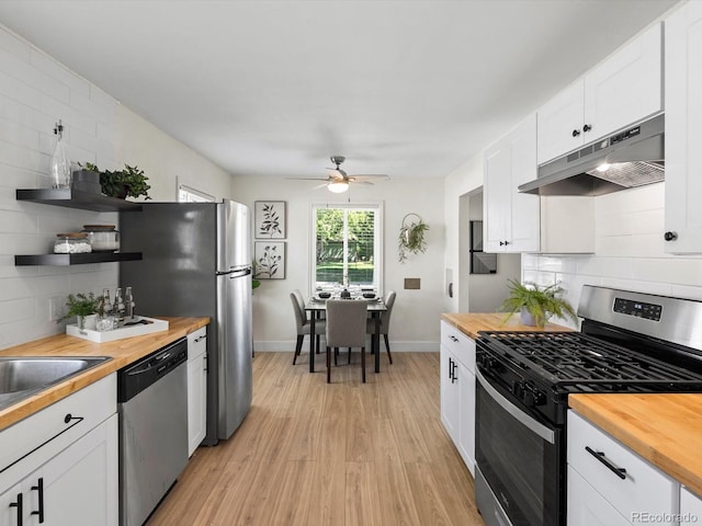 4740 W Wyoming Pl, Denver, CO 80219 - kitchen featuring stainless steel appliances, wood counters, and under cabinet range hood