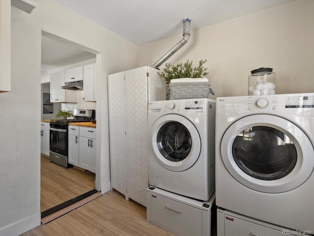 4740 W Wyoming Pl, Denver, CO 80219 - laundry room with washing machine and clothes dryer and light wood-type flooring