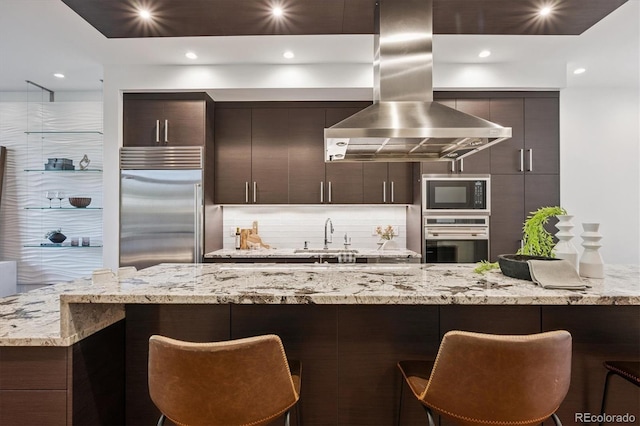 370 Garfield St, Denver, CO 80206 - kitchen featuring island exhaust hood, built in appliances, tasteful backsplash, a kitchen bar, and recessed lighting