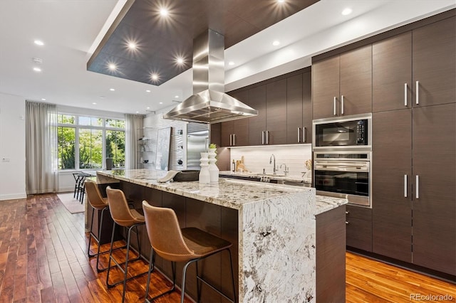 370 Garfield St, Denver, CO 80206 - kitchen with oven, black microwave, island exhaust hood, a center island, and modern cabinets
