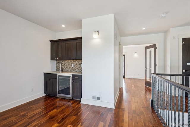 370 Garfield St, Denver, CO 80206 - indoor bar featuring wine cooler, dark wood-type flooring, decorative backsplash, and recessed lighting