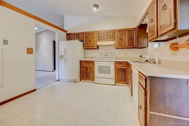 4738 Dover Dr, Colorado Springs, CO 80916 - kitchen featuring white appliances, under cabinet range hood, vaulted ceiling, light countertops, and brown cabinetry