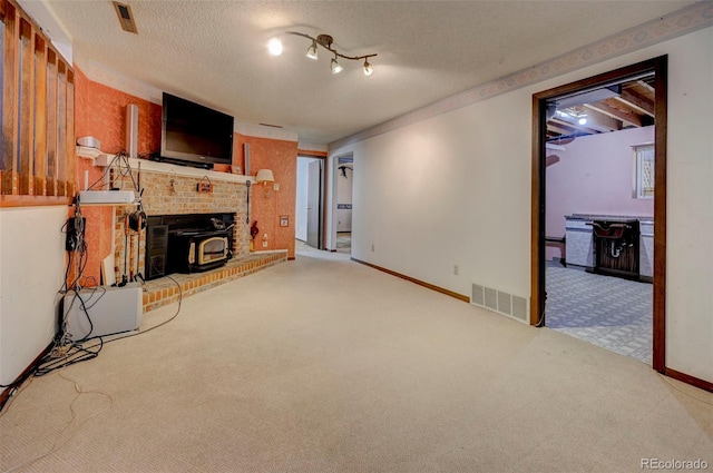 4738 Dover Dr, Colorado Springs, CO 80916 - unfurnished living room with carpet, a textured ceiling, and a wood stove