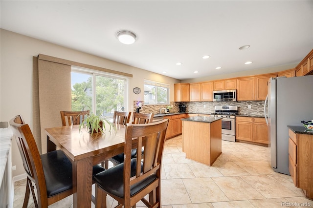2753 E 139th Dr, Thornton, CO 80602 - kitchen featuring appliances with stainless steel finishes, a center island, backsplash, recessed lighting, and dark stone countertops