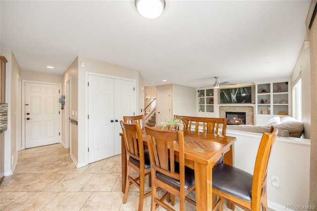 2753 E 139th Dr, Thornton, CO 80602 - dining room featuring a glass covered fireplace, ceiling fan, stairs, recessed lighting, and light tile patterned flooring