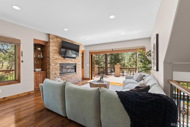 living room featuring wood finished floors, baseboards, a fireplace, and recessed lighting