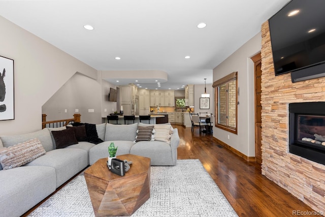 living room featuring a fireplace, recessed lighting, and dark wood finished floors