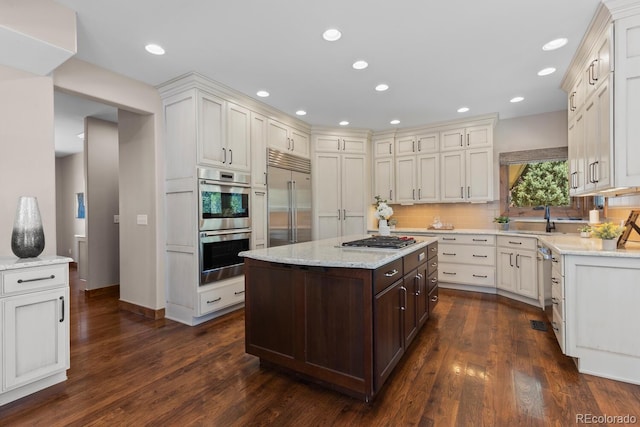 kitchen with stainless steel appliances, dark wood finished floors, decorative backsplash, and dark brown cabinetry