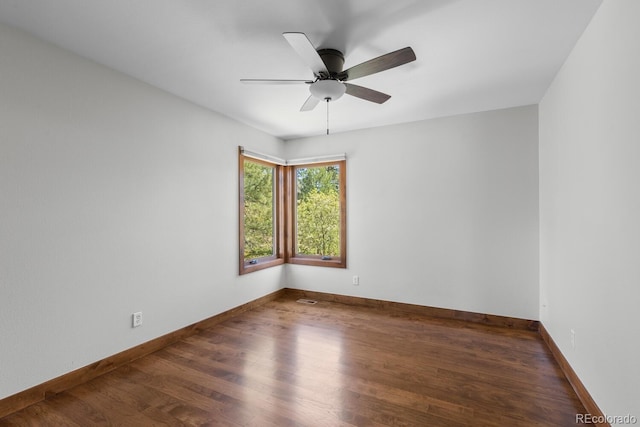 unfurnished room featuring a ceiling fan, wood finished floors, and baseboards