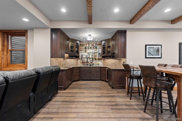 bar featuring decorative backsplash, indoor wet bar, light wood-style flooring, and recessed lighting