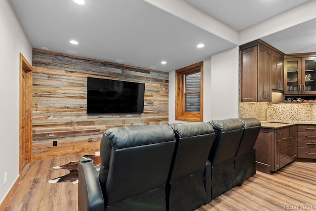 cinema featuring recessed lighting, a sink, wooden walls, an accent wall, and light wood-style floors