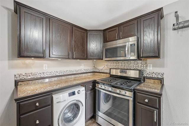 kitchen featuring dark brown cabinetry, appliances with stainless steel finishes, washer / clothes dryer, and stone counters