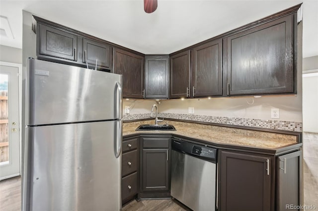 kitchen with sink, dark brown cabinets, light hardwood / wood-style floors, and appliances with stainless steel finishes