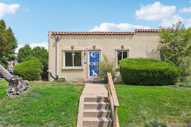 mediterranean / spanish house featuring a front yard