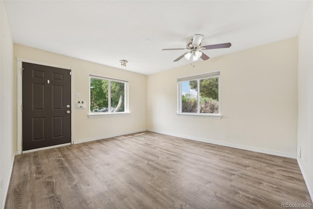 unfurnished room featuring wood-type flooring, a healthy amount of sunlight, and ceiling fan