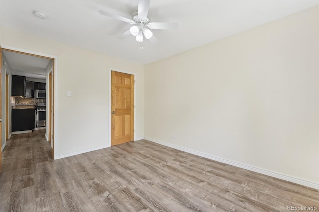 empty room featuring hardwood / wood-style flooring and ceiling fan