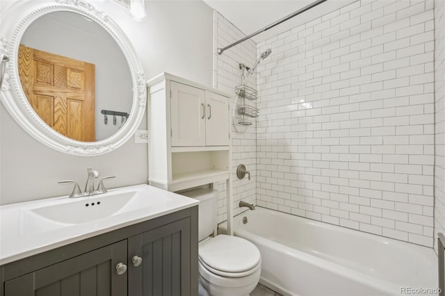 full bathroom with tiled shower / bath, vanity, and toilet