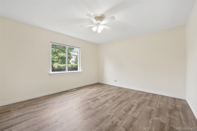 empty room with ceiling fan and light hardwood / wood-style floors