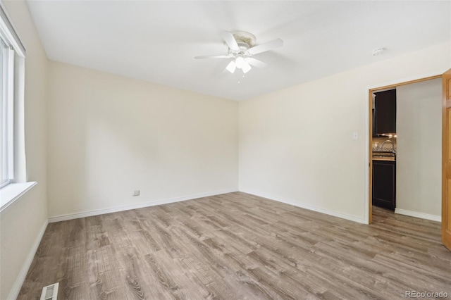 unfurnished room with plenty of natural light, sink, ceiling fan, and light hardwood / wood-style flooring