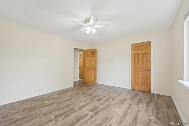 empty room with ceiling fan and light hardwood / wood-style flooring