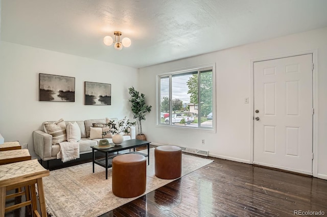 7618 Umatilla St, Denver, CO 80221 - living area with dark wood-type flooring, baseboards, and a chandelier