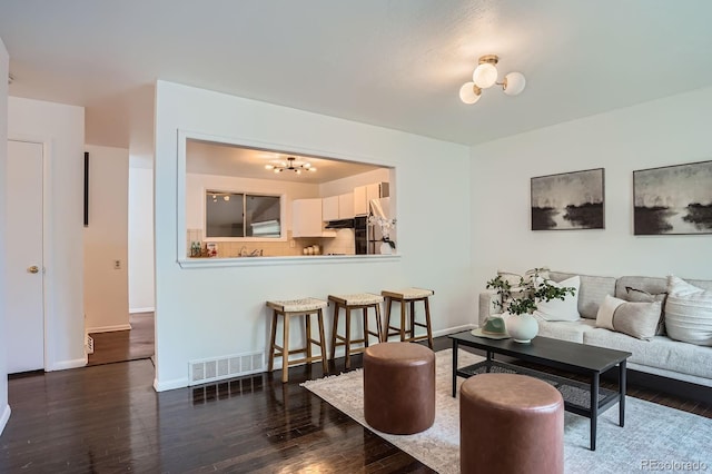 7618 Umatilla St, Denver, CO 80221 - living room featuring a chandelier, wood finished floors, and baseboards