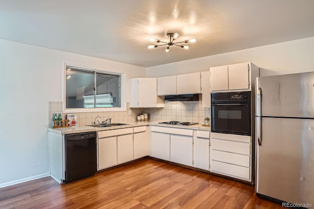 7618 Umatilla St, Denver, CO 80221 - kitchen with black appliances, a chandelier, tile counters, and decorative backsplash