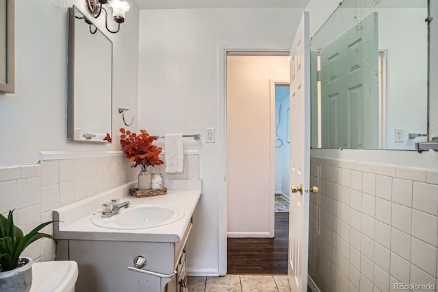 7618 Umatilla St, Denver, CO 80221 - bathroom with tile walls, vanity, tile patterned flooring, and toilet