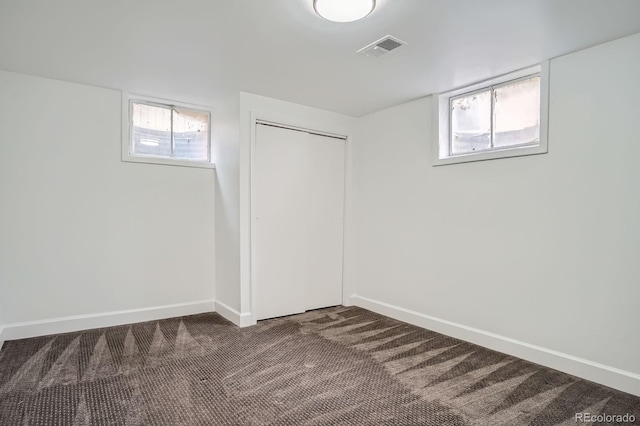 7618 Umatilla St, Denver, CO 80221 - basement featuring plenty of natural light, dark carpet, and baseboards