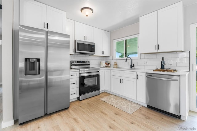 2260 S Lewiston St, Aurora, CO 80013 - kitchen with stainless steel appliances, light countertops, backsplash, light wood-style floors, and white cabinetry