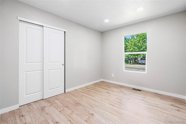 2260 S Lewiston St, Aurora, CO 80013 - unfurnished bedroom featuring light wood-style floors, a closet, and recessed lighting
