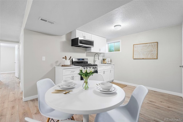 2260 S Lewiston St, Aurora, CO 80013 - dining area featuring light wood-type flooring and a textured ceiling