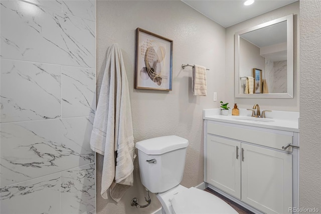 2260 S Lewiston St, Aurora, CO 80013 - bathroom featuring vanity, a textured wall, and marble look tiles