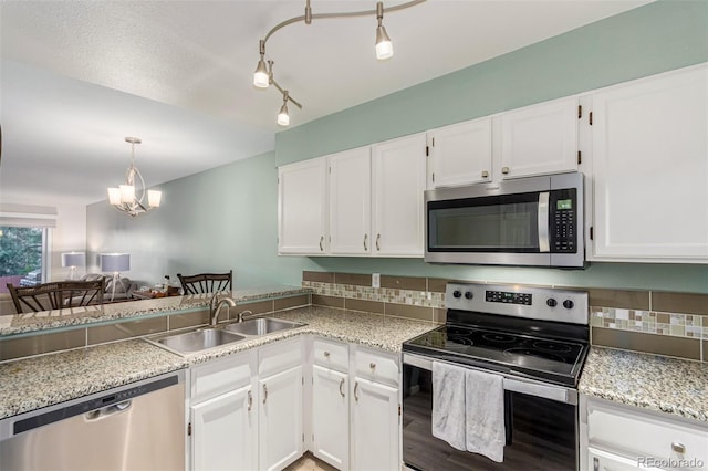 11147 W 17th Ave Unit 103, Lakewood, CO 80215 - kitchen with a sink, white cabinetry, tasteful backsplash, and stainless steel appliances